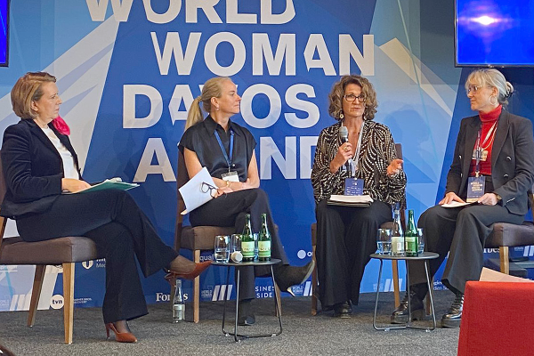 Four women sit on a stage for a panel discussion